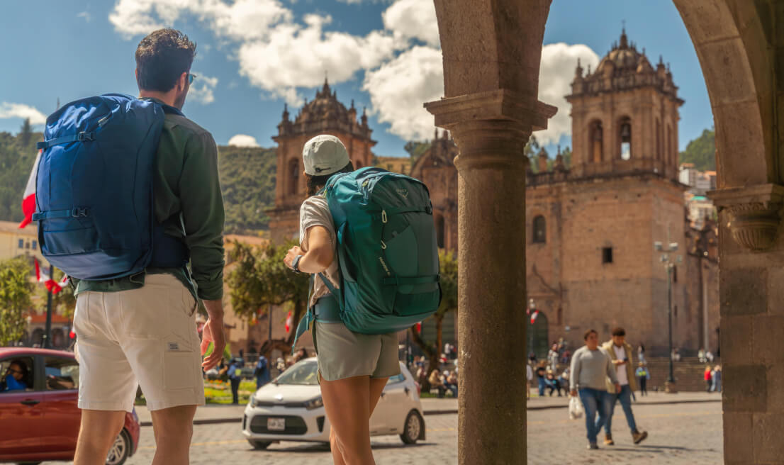 Travelers with Osprey Farpoint and Fairview backpacks in historic city square
