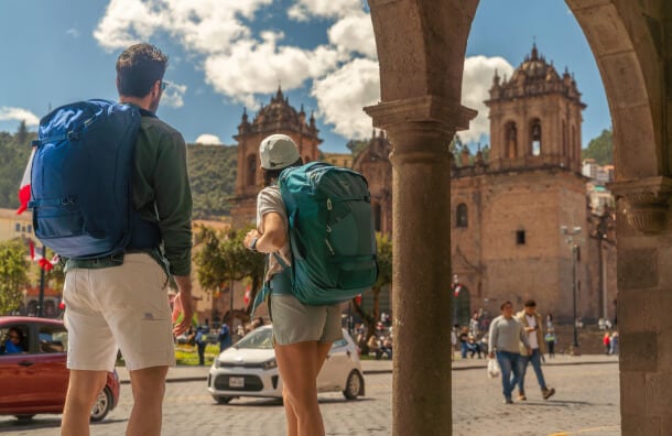 Travelers with Osprey Farpoint and Fairview backpacks in historic city square