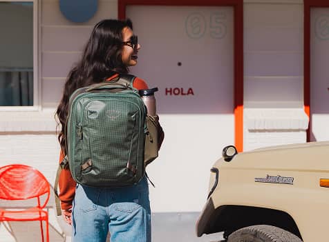 Person wearing an Osprey travel backpack while walking through a destination setting.