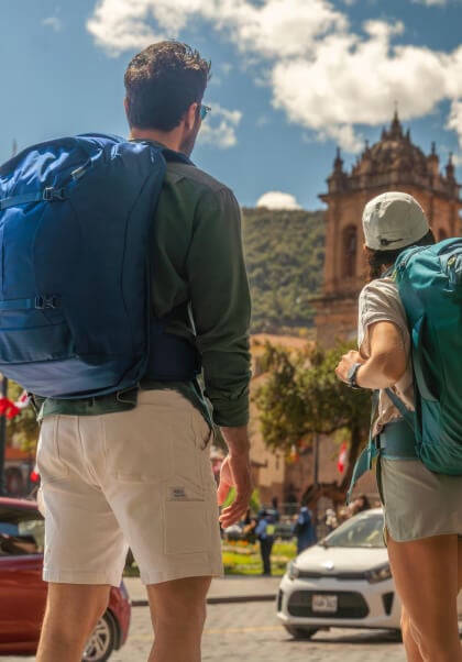 Travelers with Osprey Farpoint and Fairview backpacks in historic city square