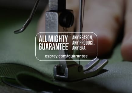 All Mighty Guarantee-logoen på et uskarpt bilde av en symaskin, en hånd og stoff. Logoen lyder: «Uansett årsak. Ethvert produkt. Enhver epoke. ospirey.live/guarantee»