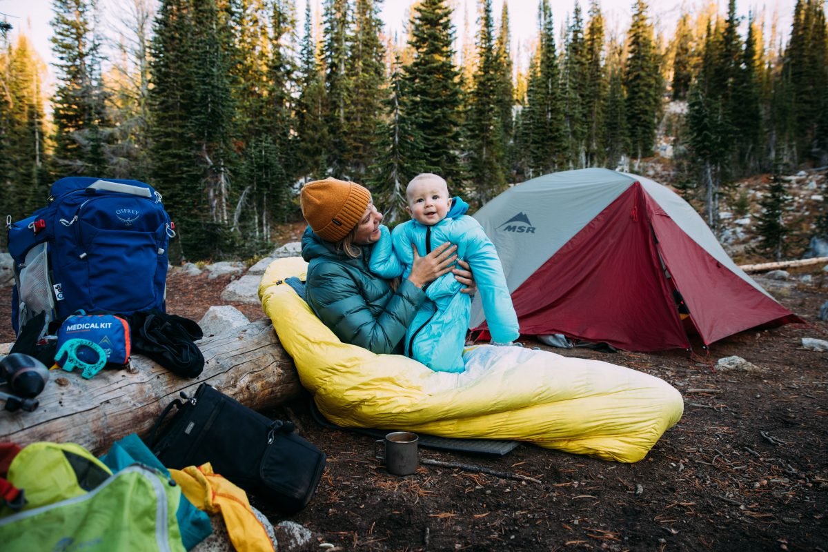 Mom and baby sitting in a sleeping bag