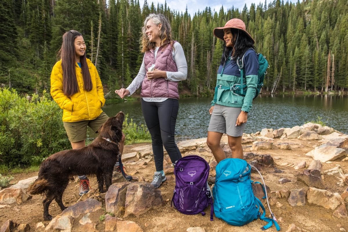 Hikers on trail with a dog and their gear
