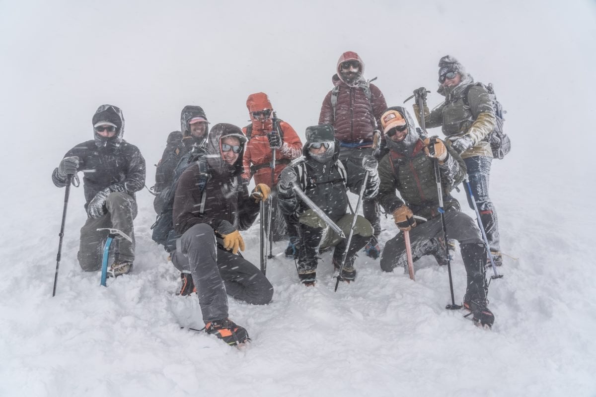 A group of people standing on a snow covered mountain.