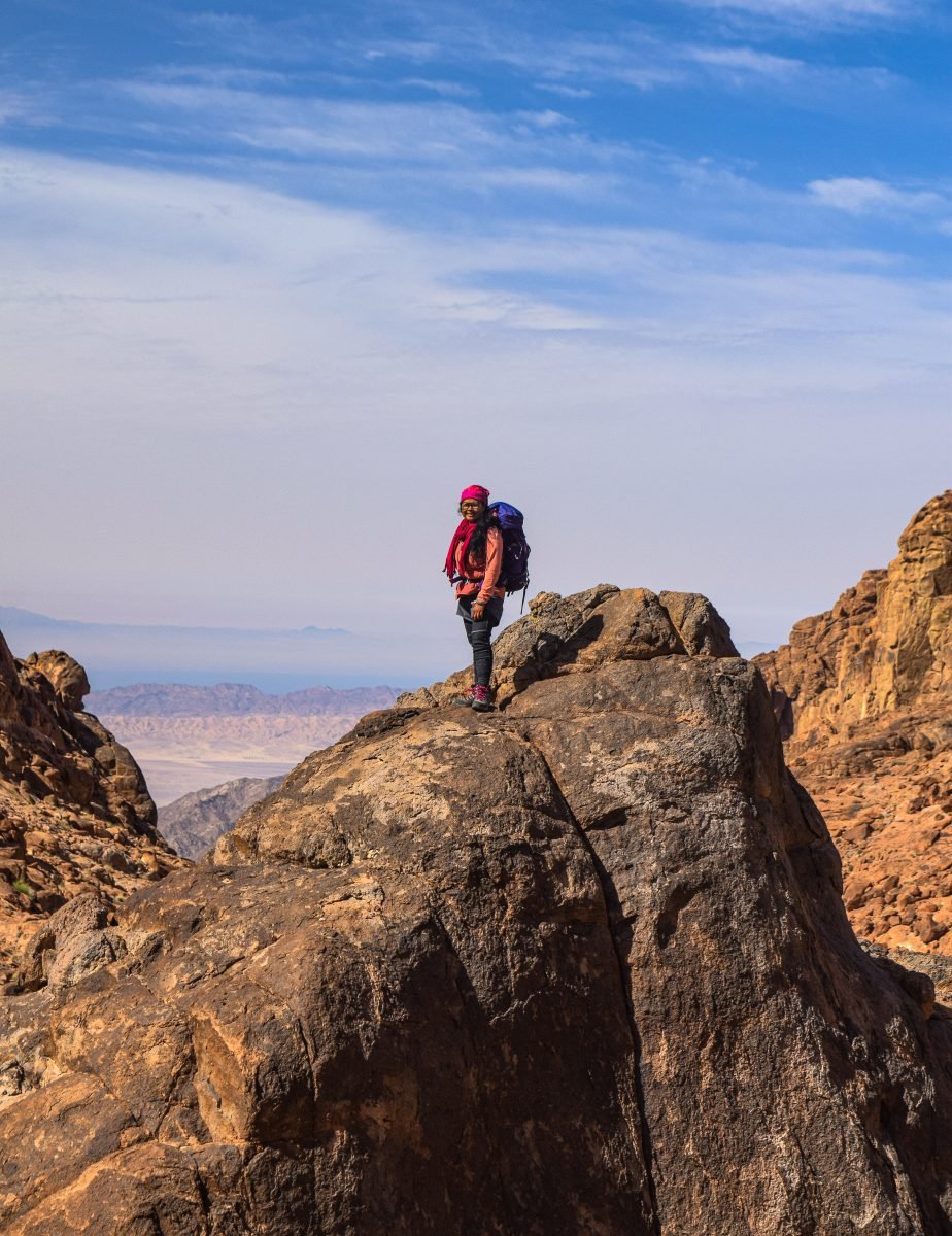 A woman standing on a rocky overlook
