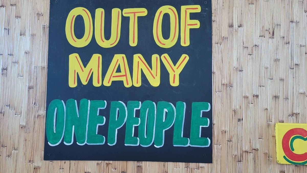 A blue sign with yellow and turquoise writing that reads 