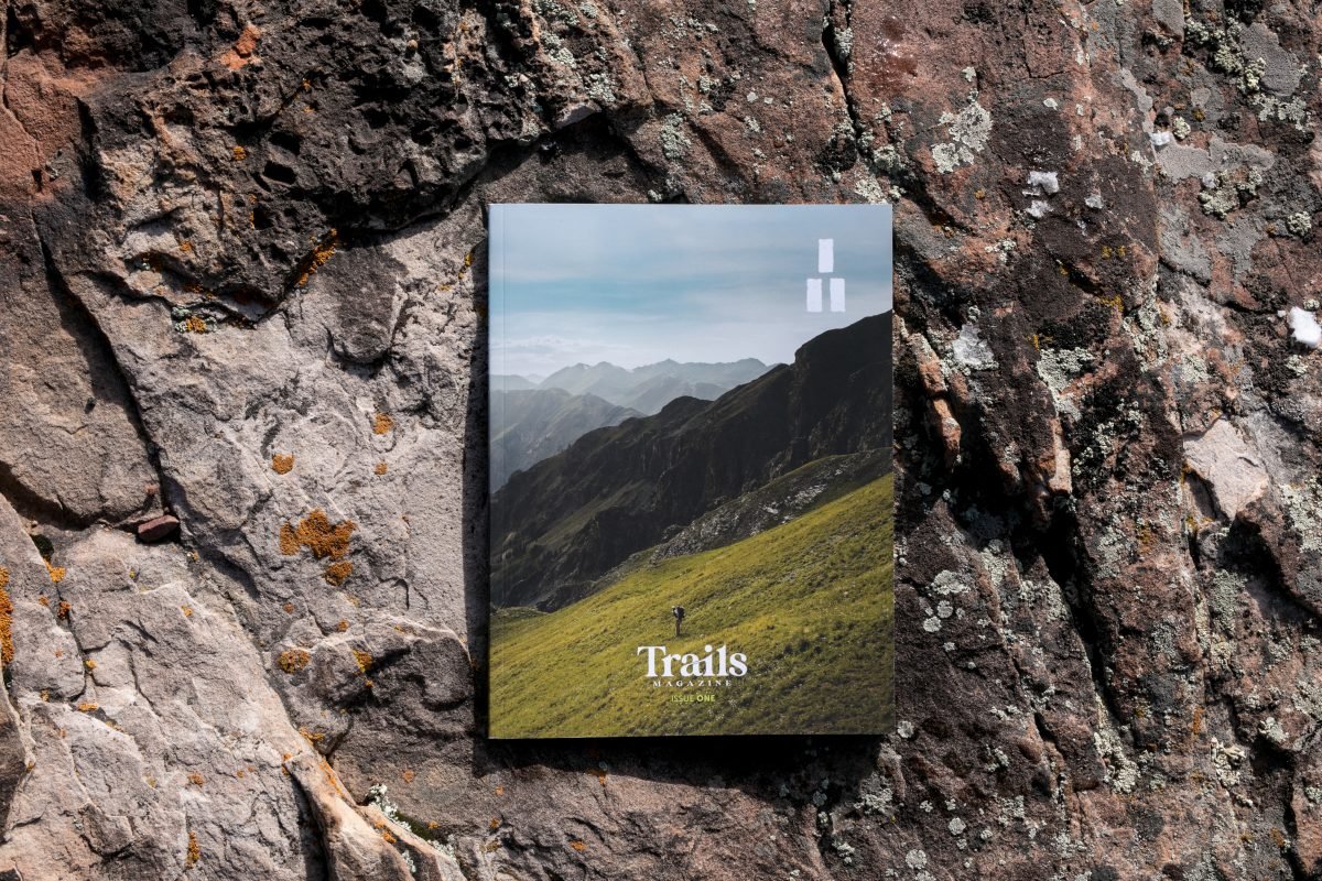 The cover of Trails Magazine on a rocky surface