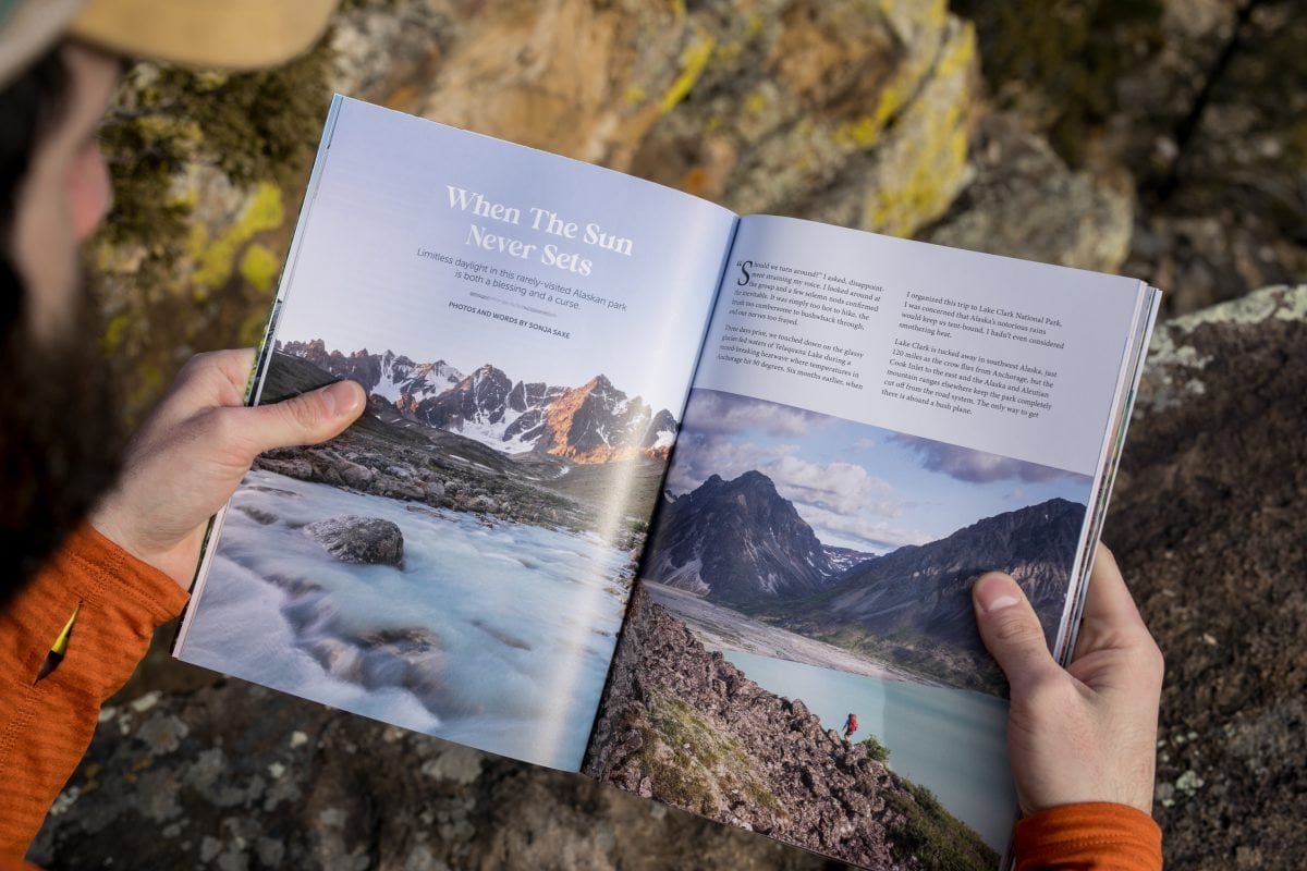 A person holding a magazine open to the first page of an article