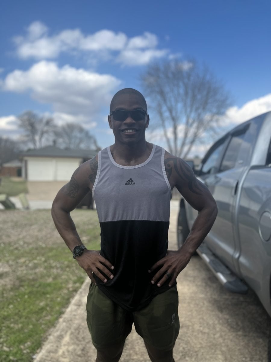 A man in running gear posing with his hands on his hips