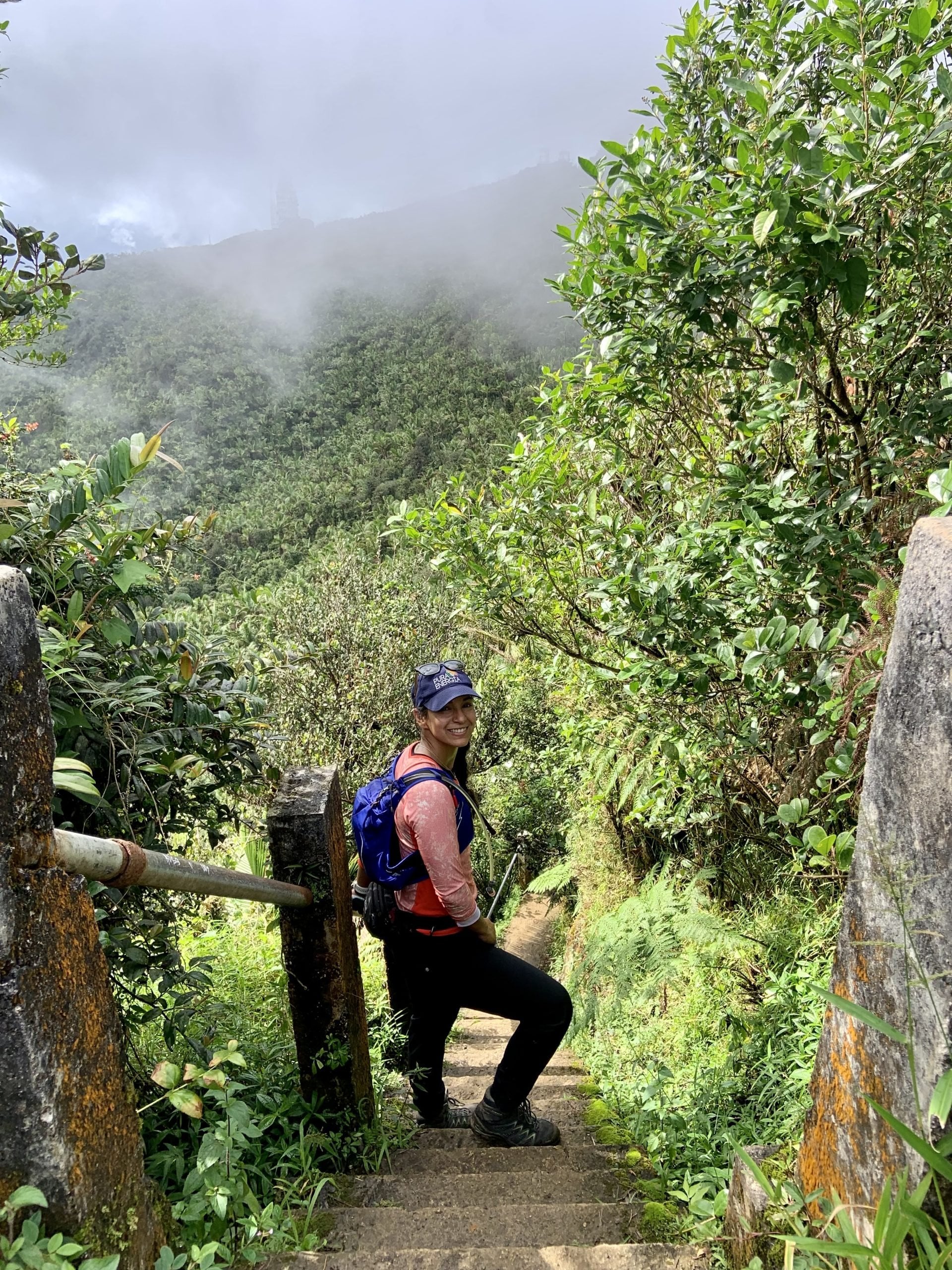 A women in running gear standing on a set of stairs along the Veredas Noreste trail