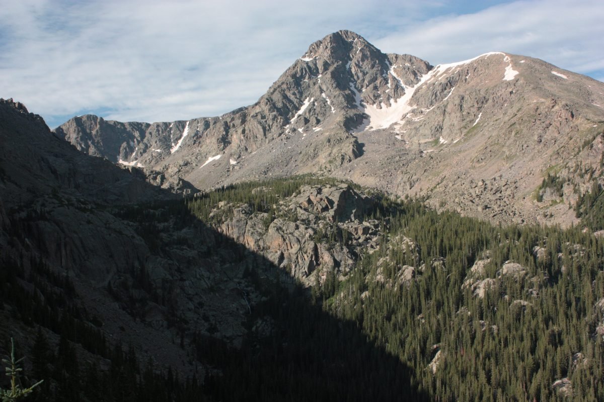 The view from Mount of the Holy Cross - looking over slightly snowcapped mountain peaks with trees below