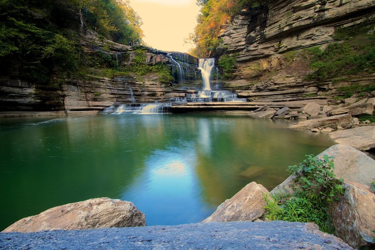 A cascading waterfall falling into a swimming hole