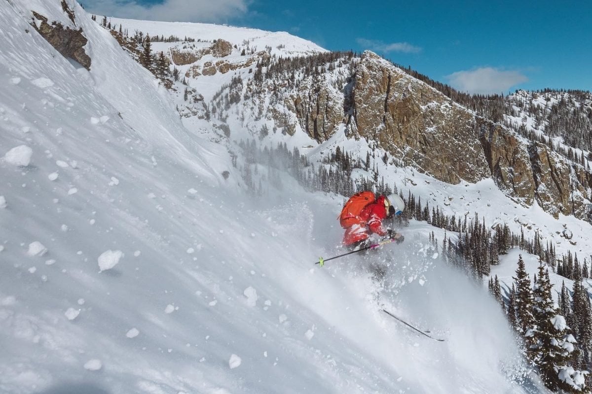 A person skiing down a snow covered mountain