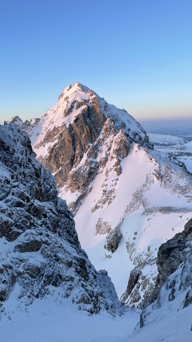 A portrait view of a snow covered peak in the Tetons