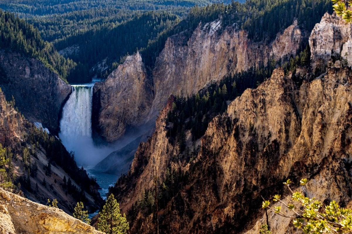 A waterfall nestled into a mountainous landscape in Yellowstone National Park