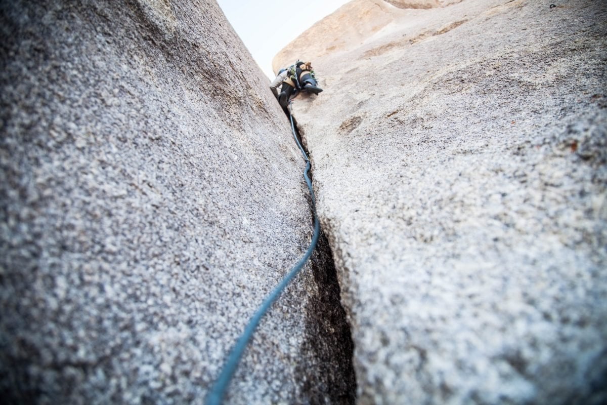 An upward view of a person rock climbing