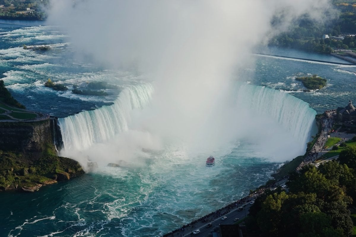 A birds eye view of Niagara Falls with mist and clouds in the sky above
