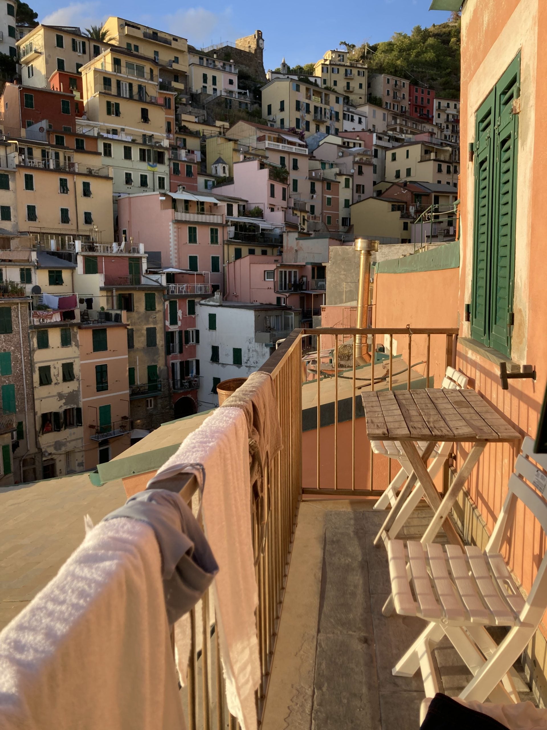 The view from a balcony, looking out at a view of costal village buildings of all colors