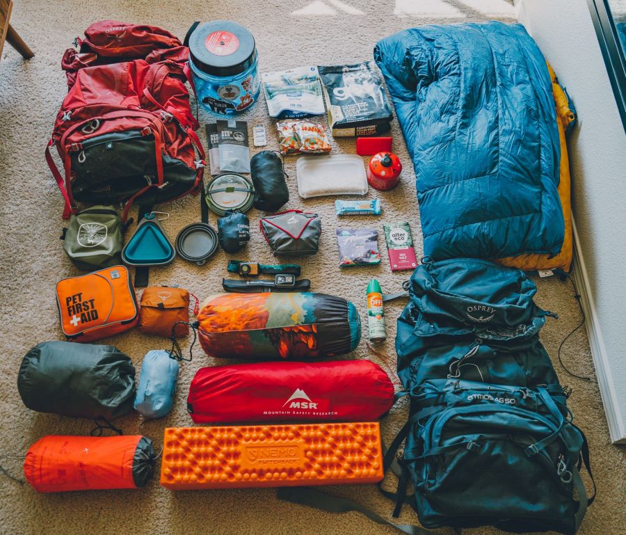 Backpacking gear laid on in an organized fashion on the floor