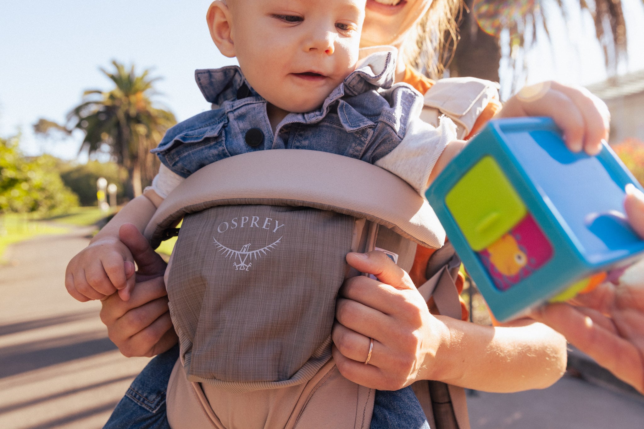 Mother carrying her baby on her front with an Osprey baby carrier