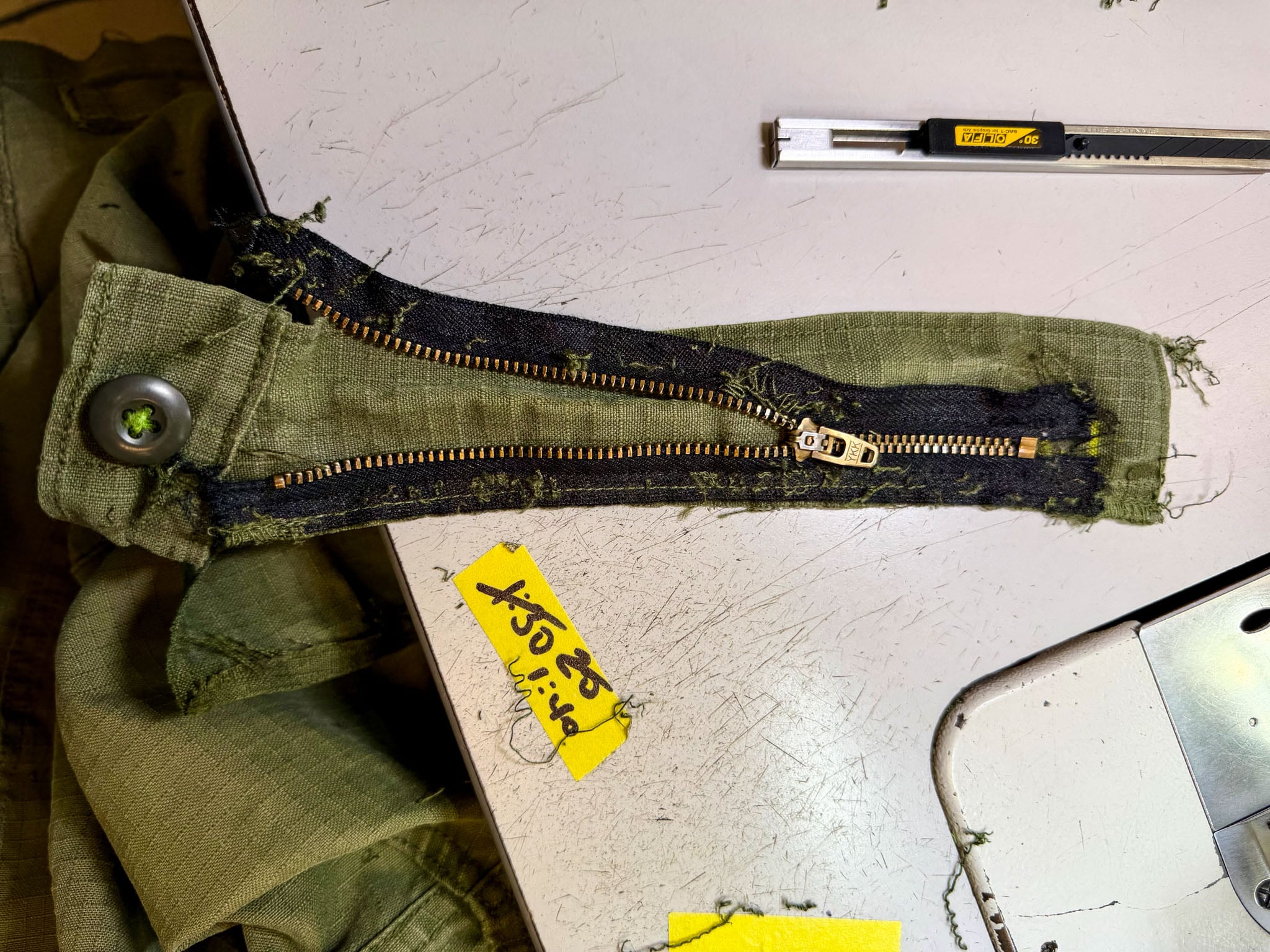 A zipper from a pair of pants taken apart for repair.