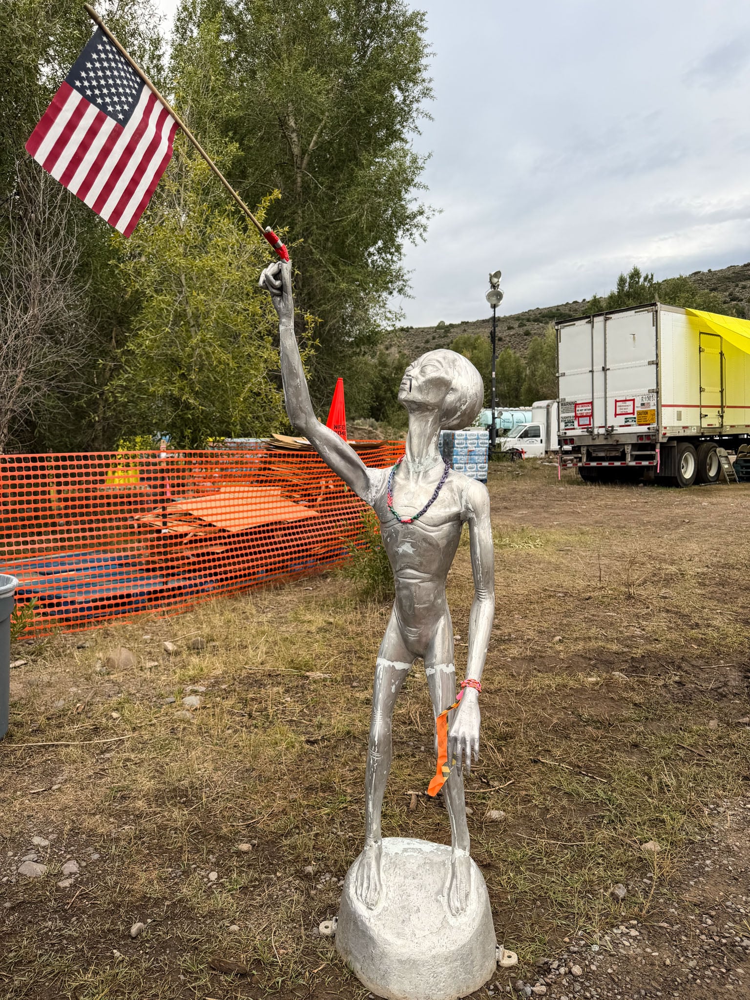 An alien statue with an American flag taped to its finger.