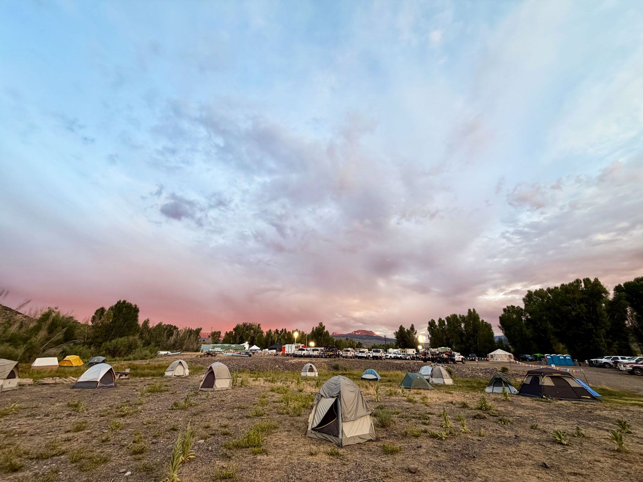 A group of tents under a sunset.