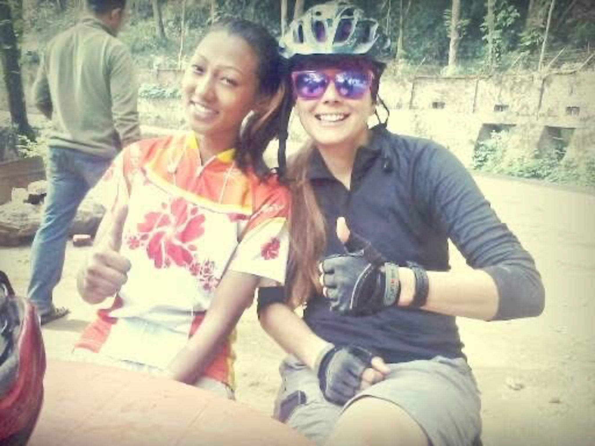 Two people in cycling gear pose for the camera.