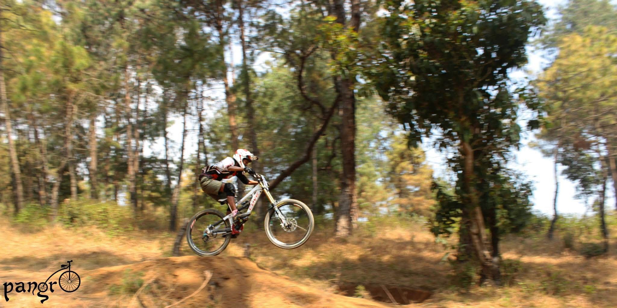 A person hits a jump on a mountain bike.