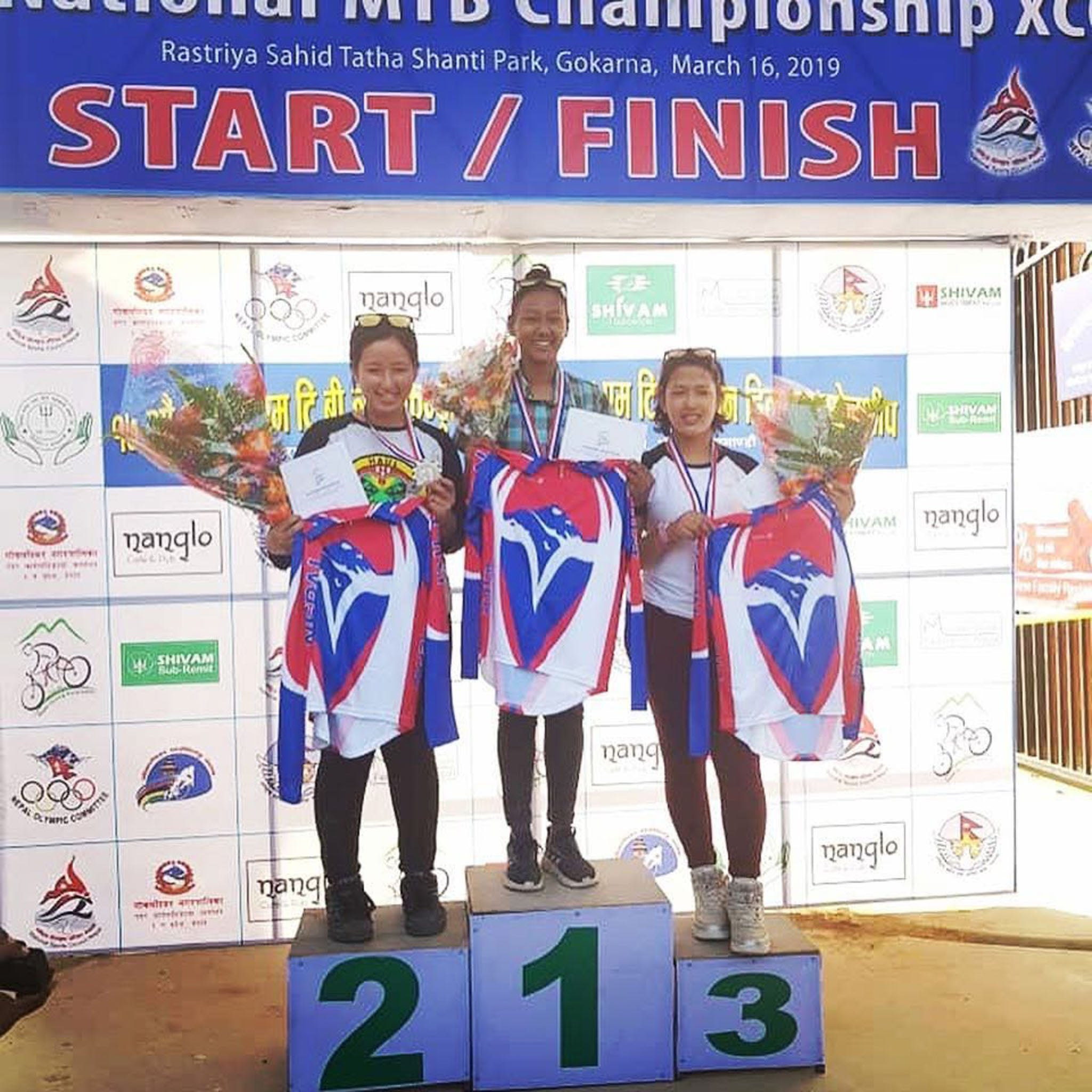Three people stand on a podium.