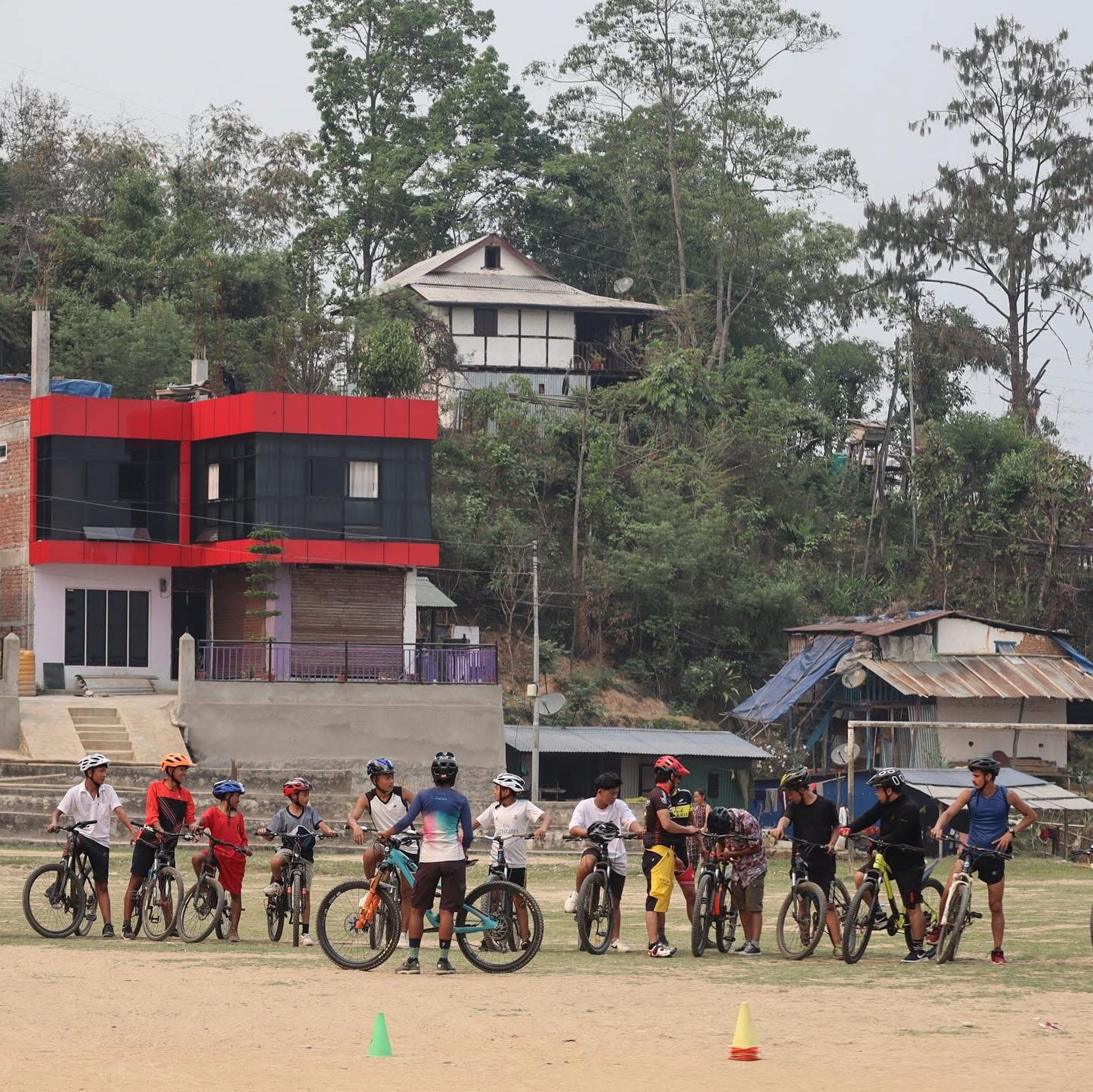 A group of cyclists line up behind some cones for a cycling course.