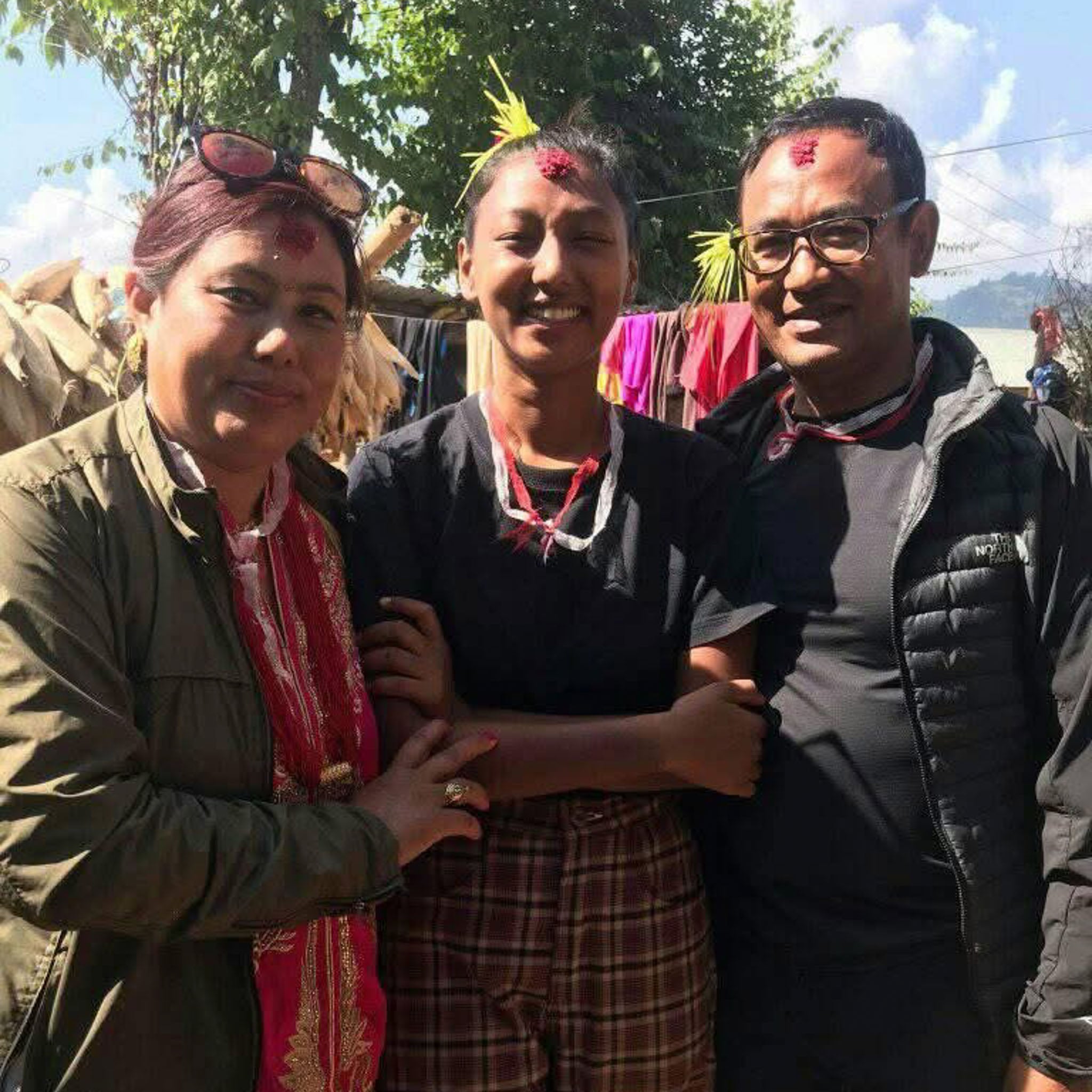 Three people pose for the camera, smiling.