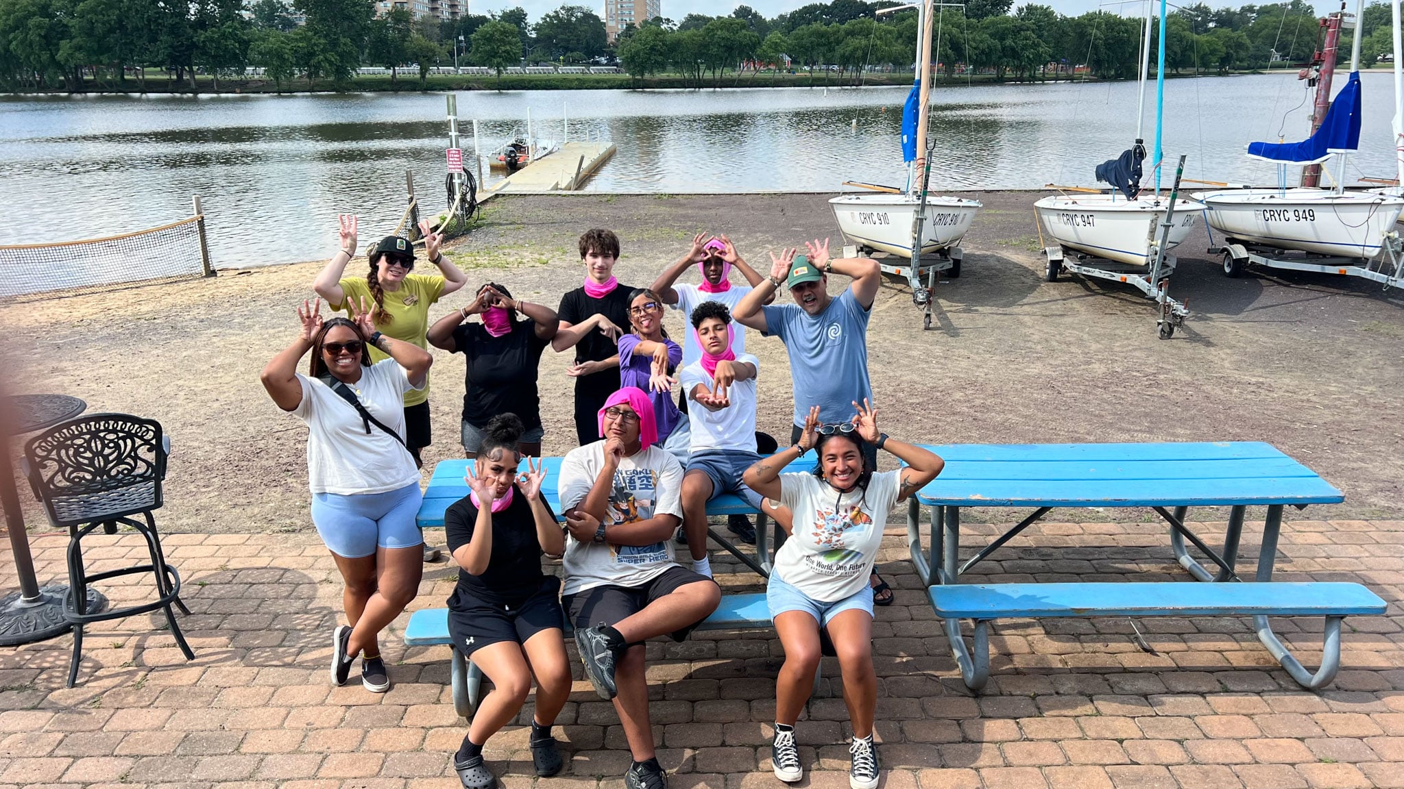 A group of people pose making their favorite LNT Principle hand signal.
