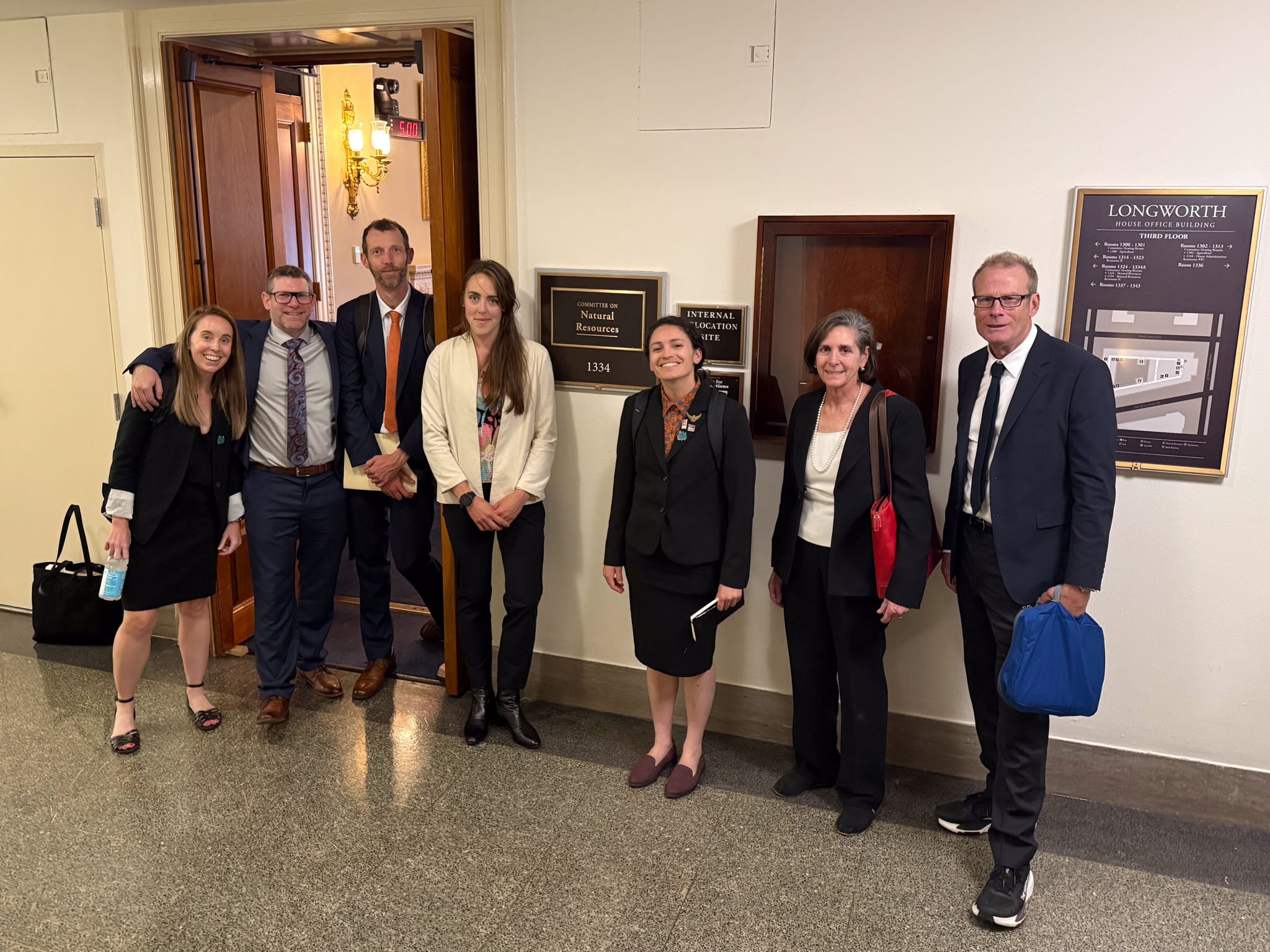 A group of people pose outside an office.