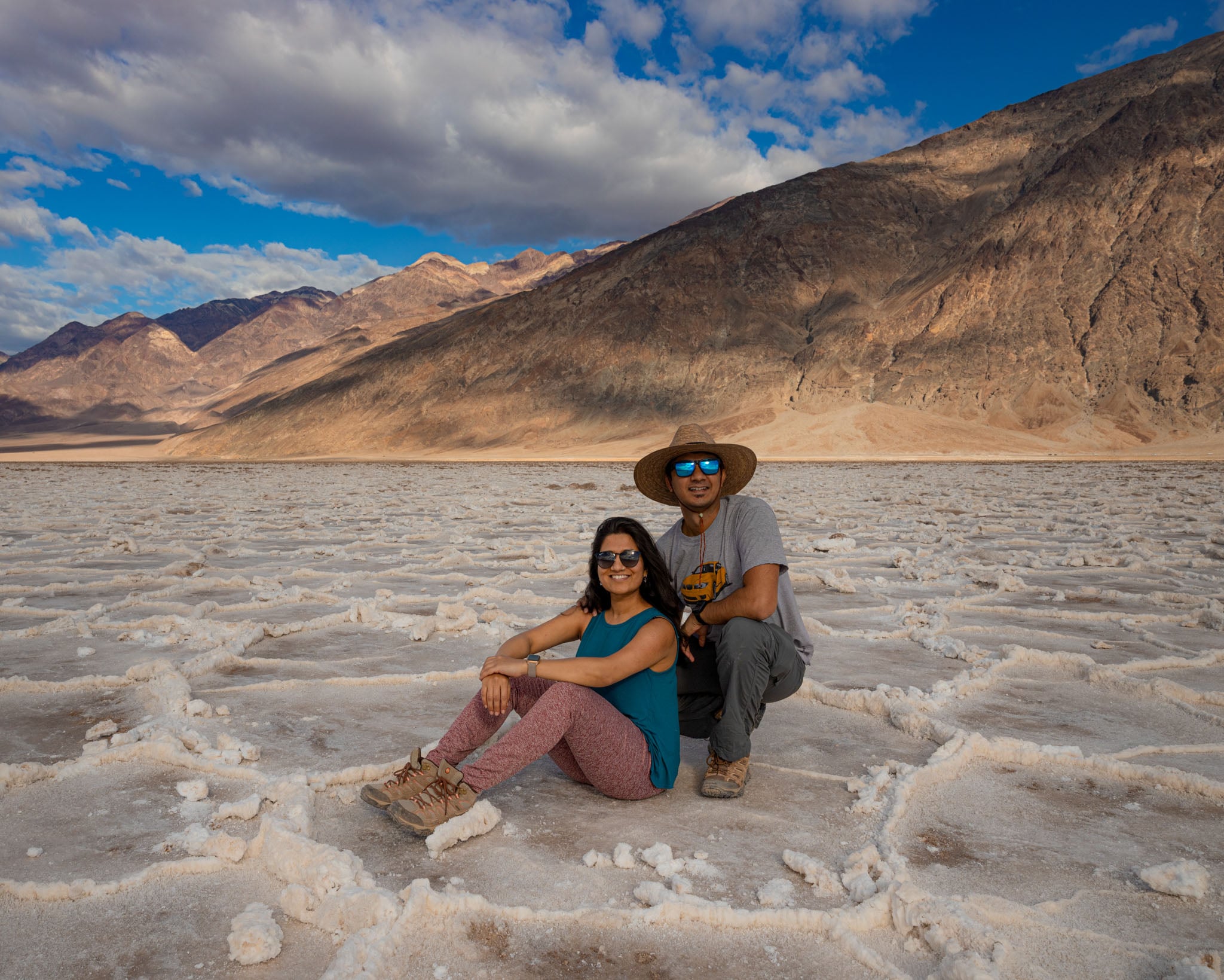 Two people sit in a dry riverbed.