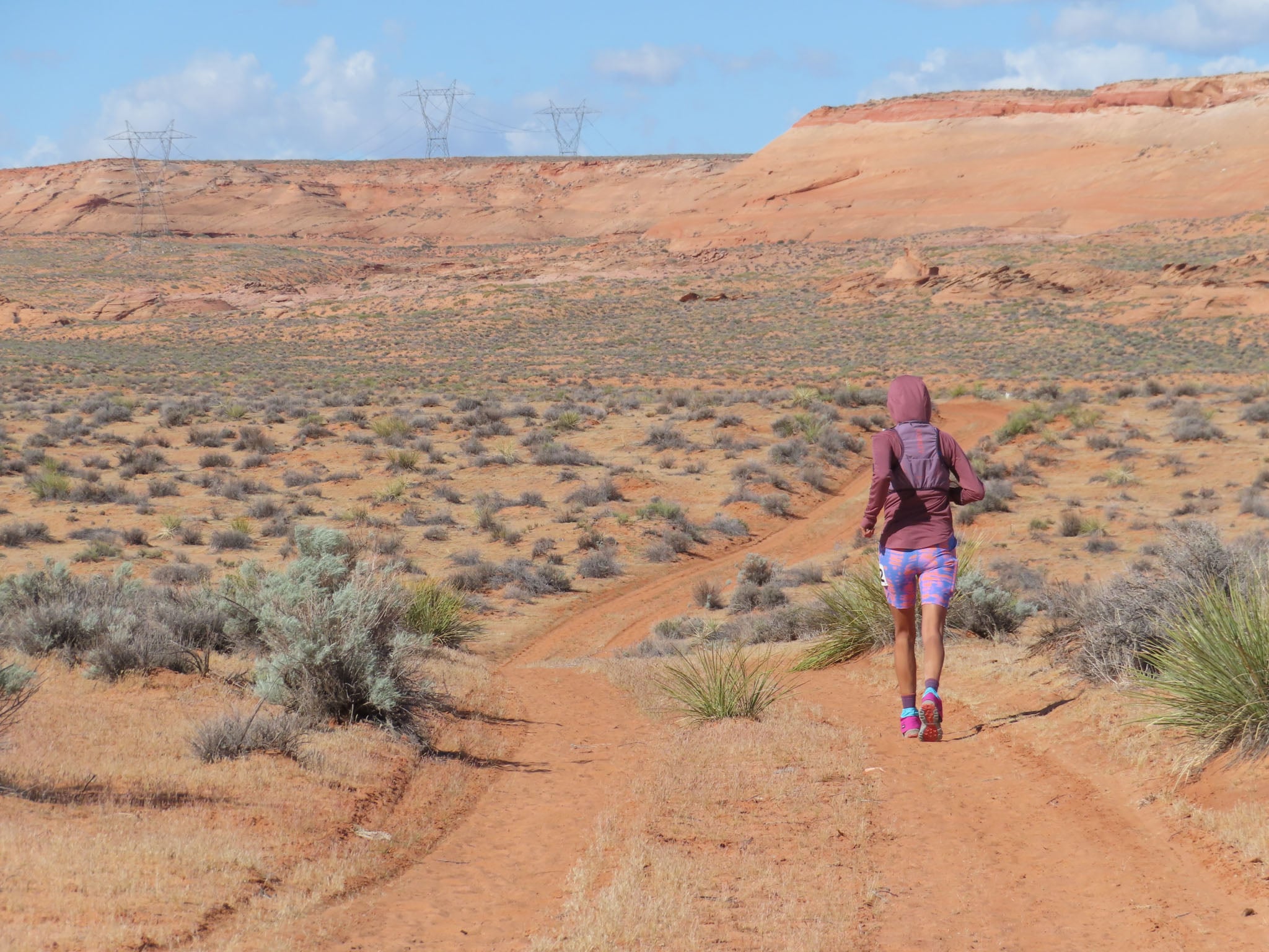 A person runs on a desert trail.