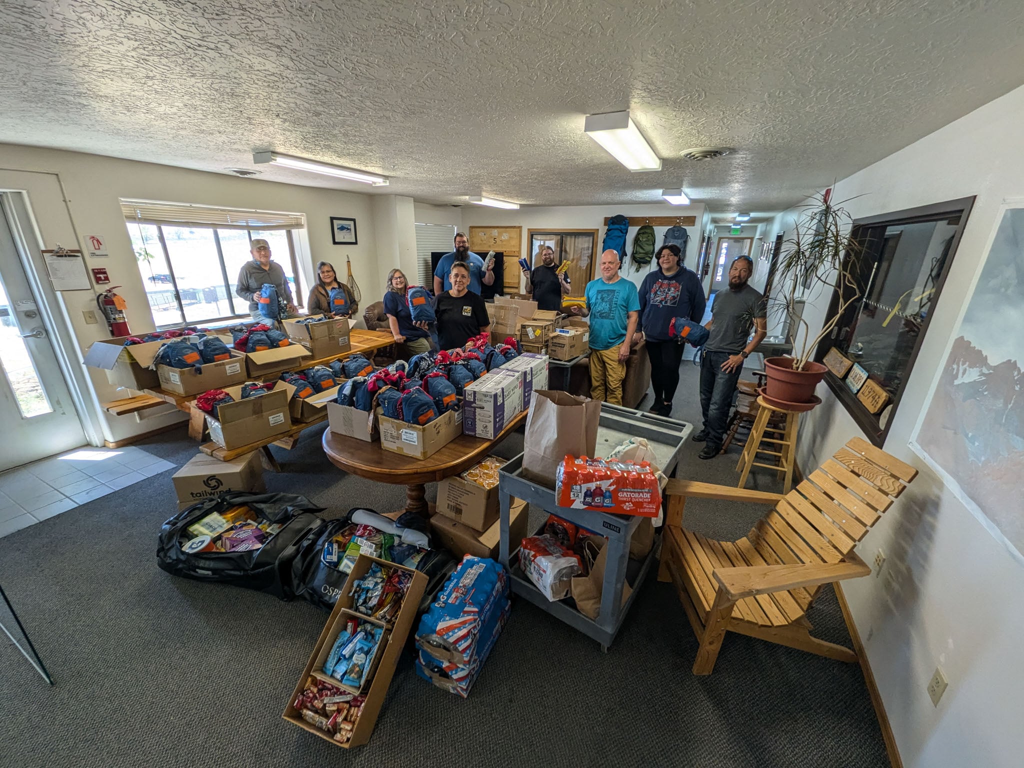 A group of people pose indoors with a large donation.