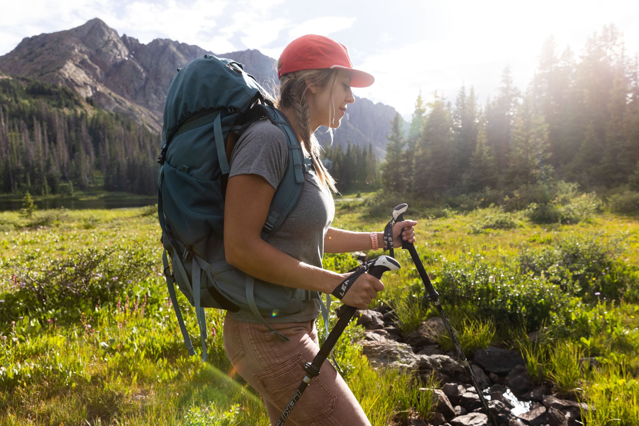 Woman hiking with a hiking backpack and trekking poles.