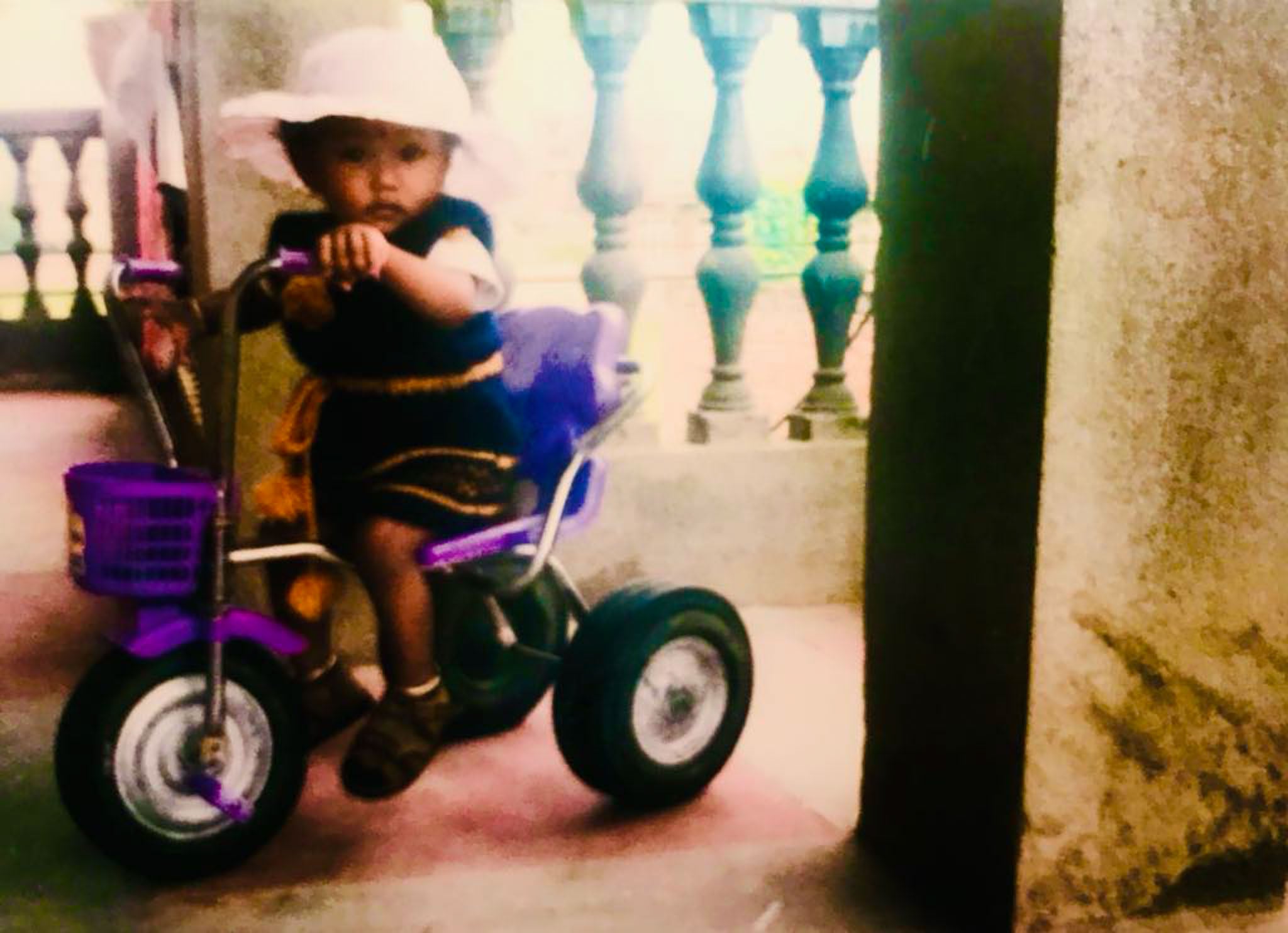 A child sits on a bicycle.
