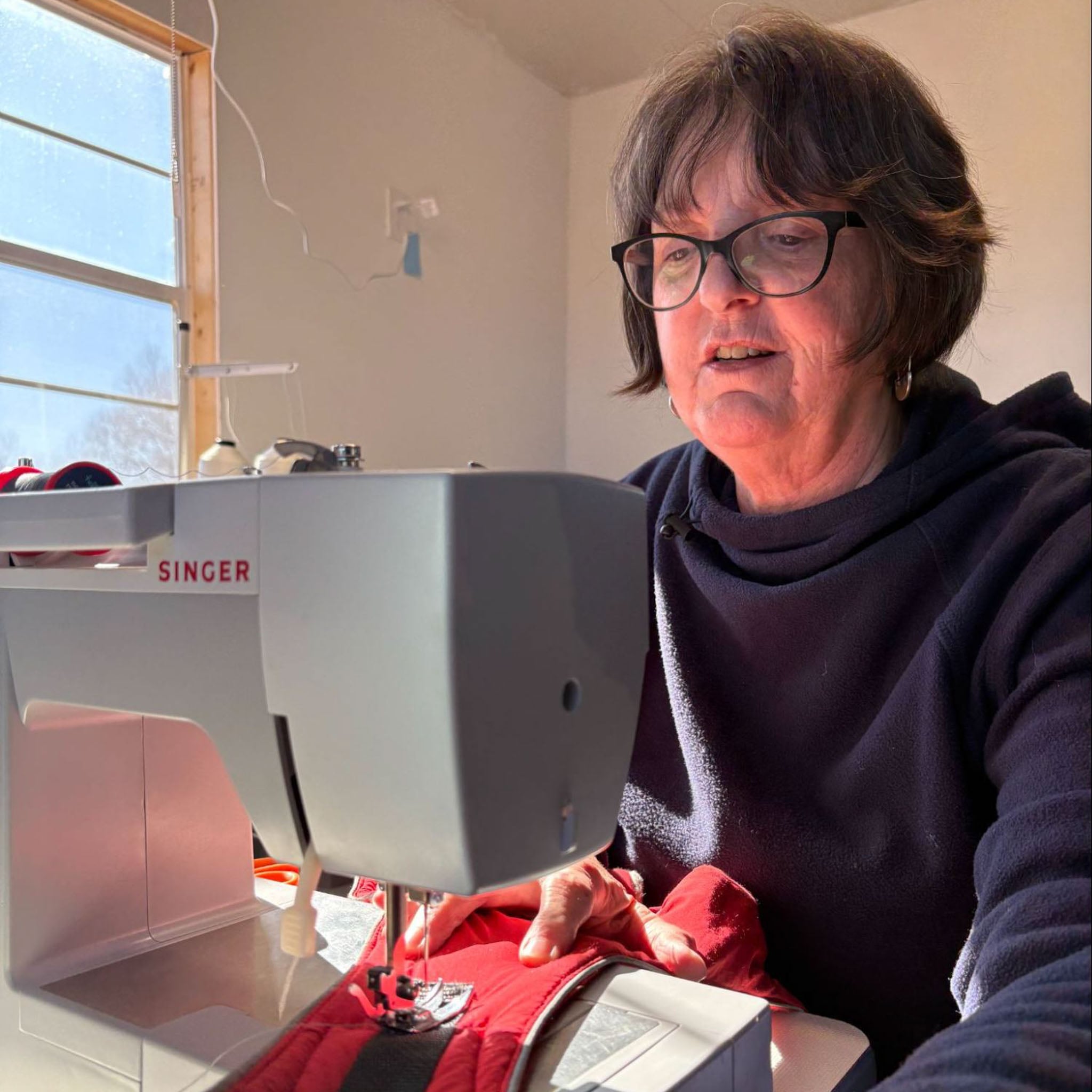 A person sits at their sewing machines.