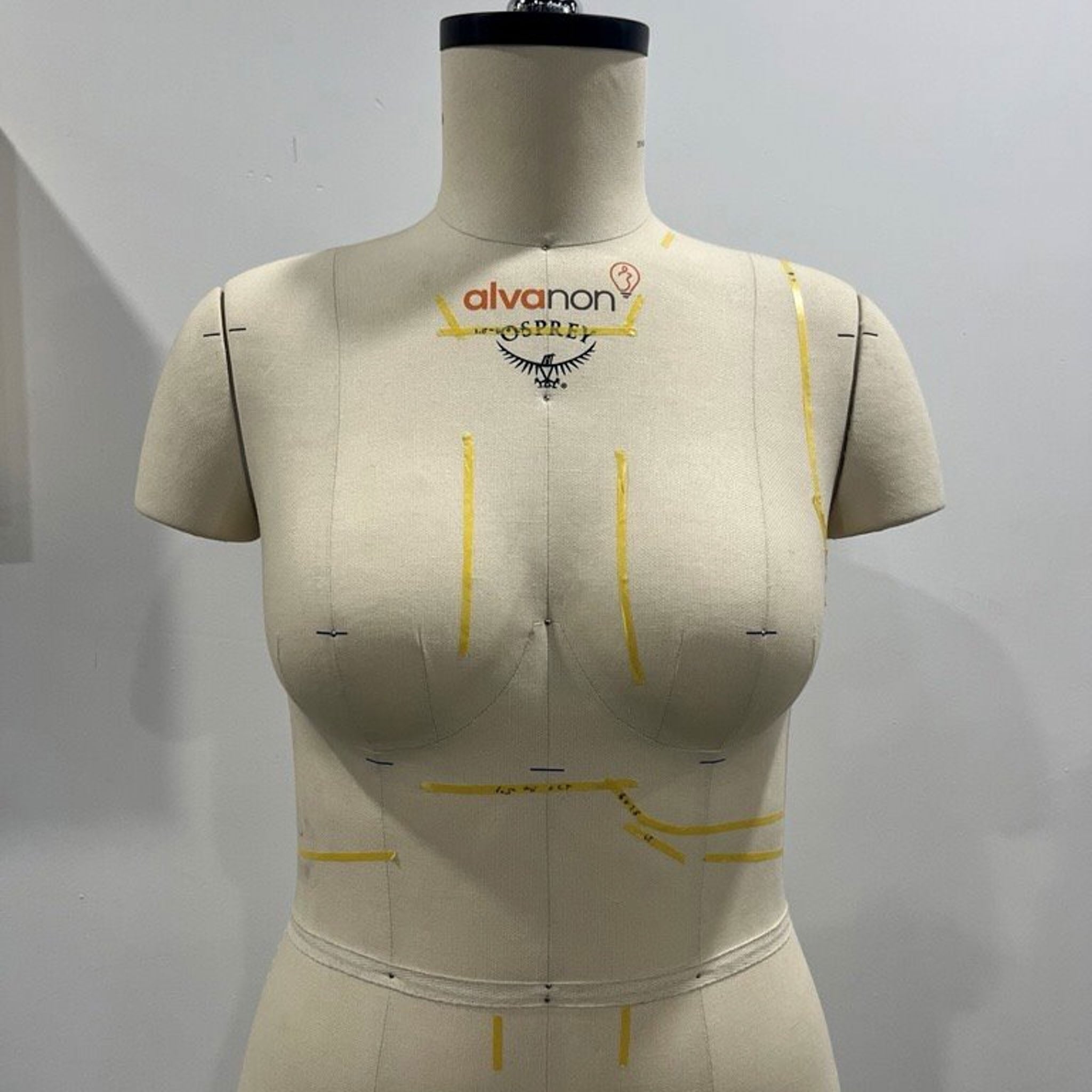 A female pack mannequin marked with tape.