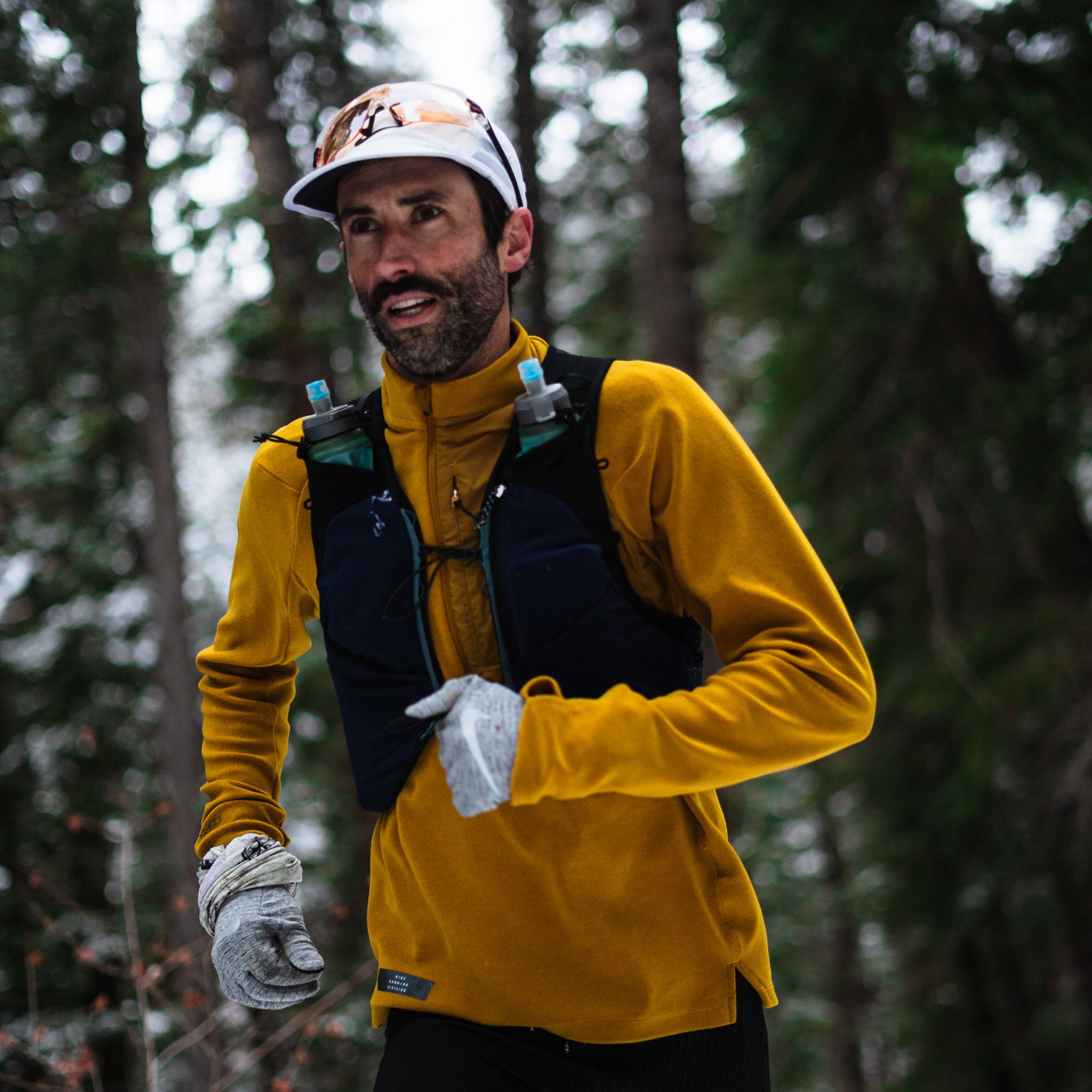A person in a yellow jacket and grey gloves runs by the camera.